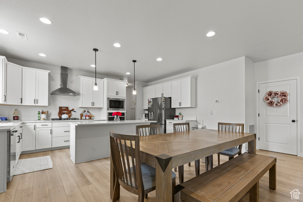 Dining room with light wood-type flooring and recessed lighting