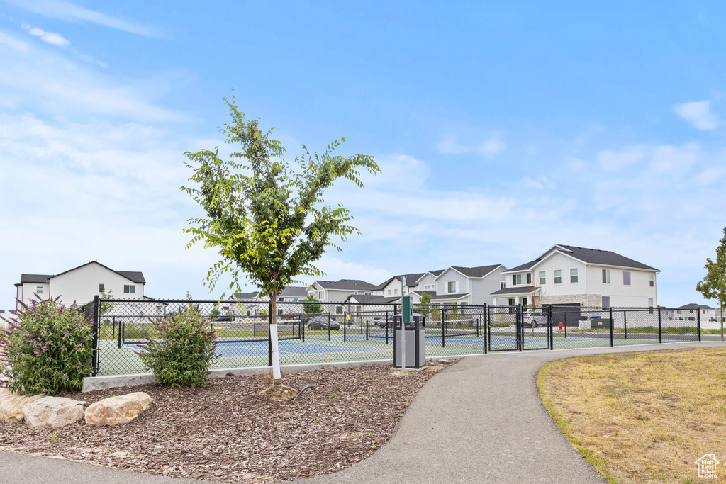 View of home's community featuring a gate, a residential view, and a tennis court