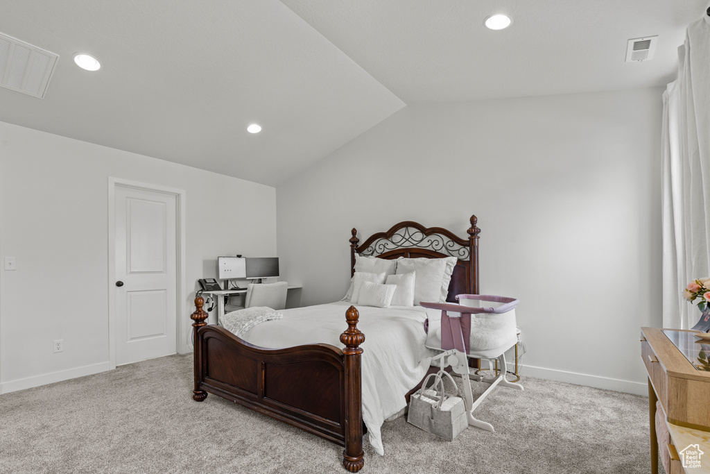 Carpeted bedroom with vaulted ceiling and recessed lighting