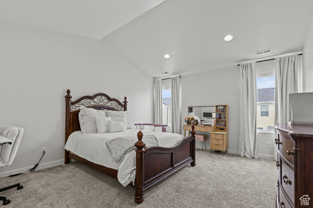 Bedroom with multiple windows, light carpet, vaulted ceiling, and recessed lighting