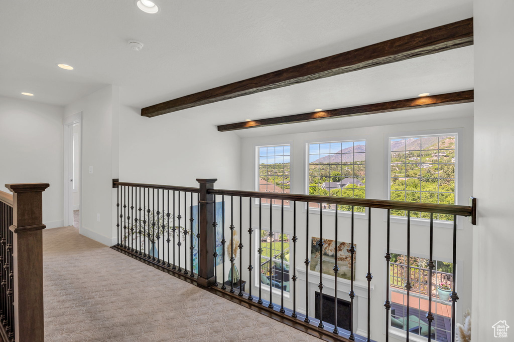 Hallway with recessed lighting, carpet flooring, beam ceiling, and an upstairs landing
