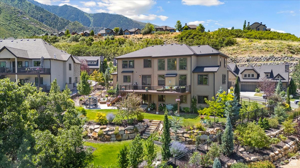 Back of property with stairway, stucco siding, a residential view, and a deck with mountain view
