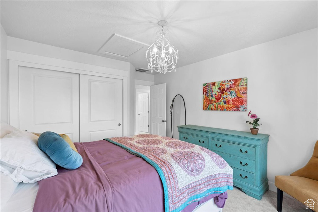 Bedroom with light carpet, a closet, and attic access
