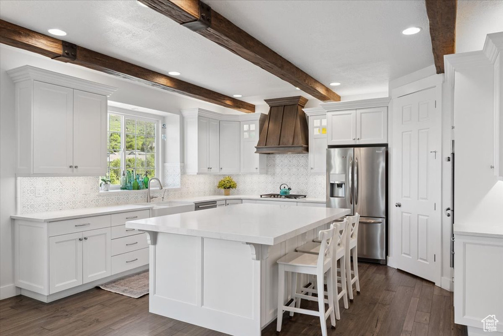 Kitchen with stainless steel fridge with ice dispenser, premium range hood, dark wood-type flooring, white cabinets, and recessed lighting
