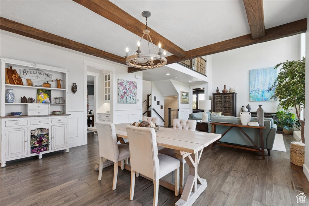 Dining space with beamed ceiling, dark wood-style flooring, and a chandelier