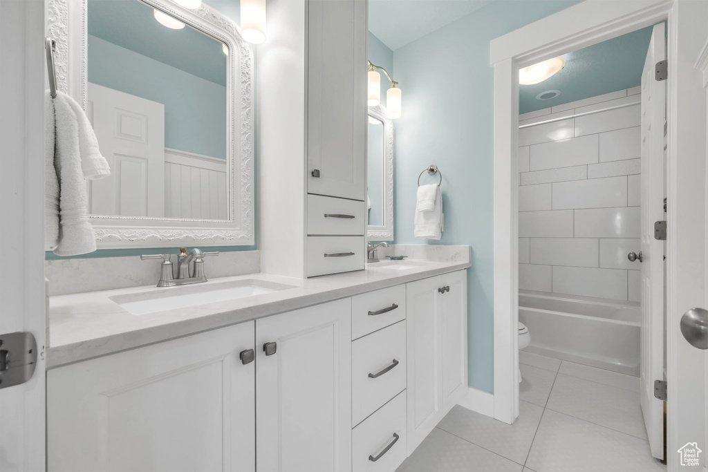 Full bathroom featuring double vanity, tile patterned flooring, and shower / bathtub combination