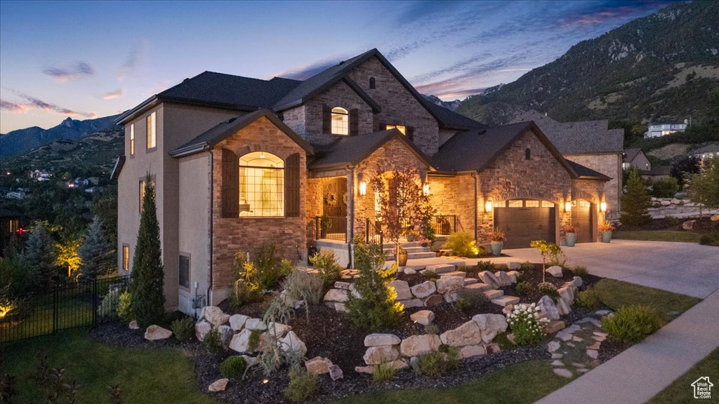 View of front of home with stone siding, concrete driveway, and a mountain view