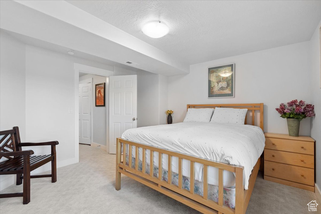 Bedroom featuring light carpet and a textured ceiling