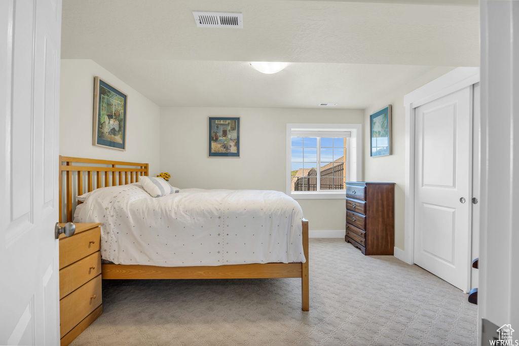 Bedroom featuring light carpet and baseboards
