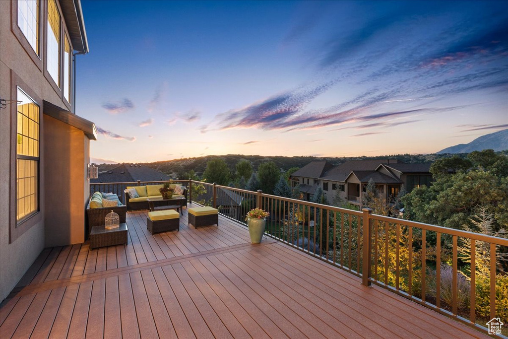 Deck at dusk with an outdoor hangout area and a mountain view