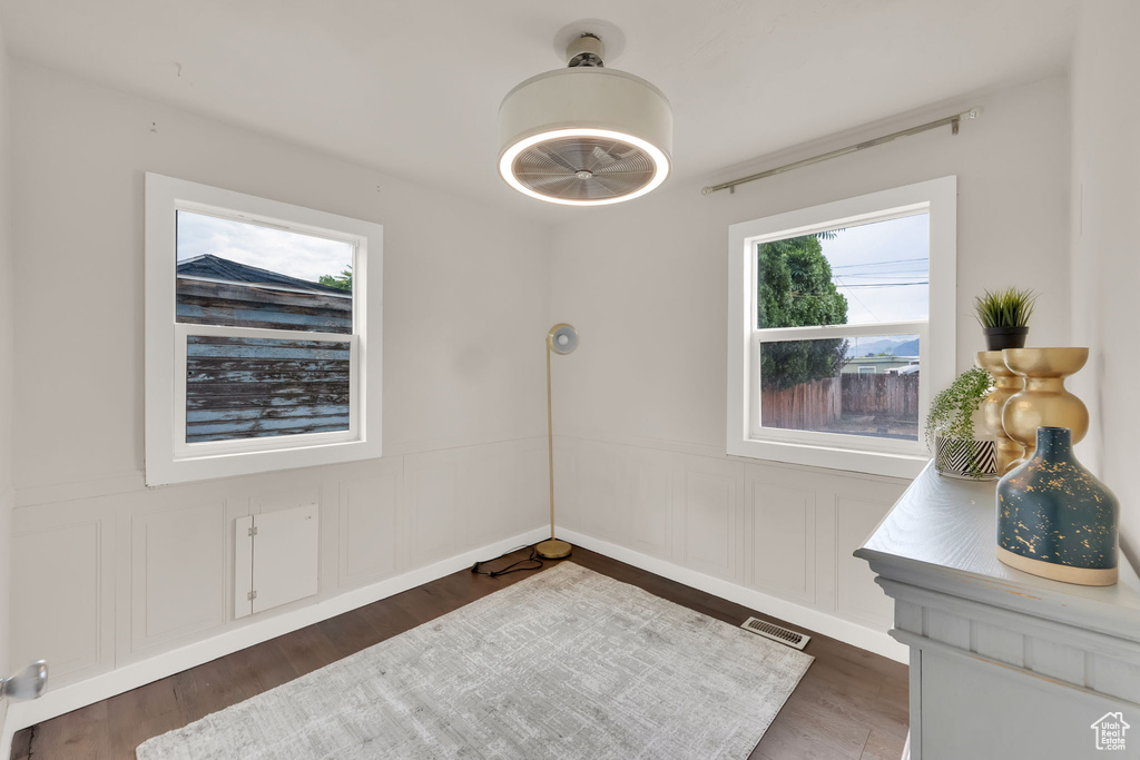 Unfurnished dining area with a wainscoted wall, wood finished floors, and a decorative wall