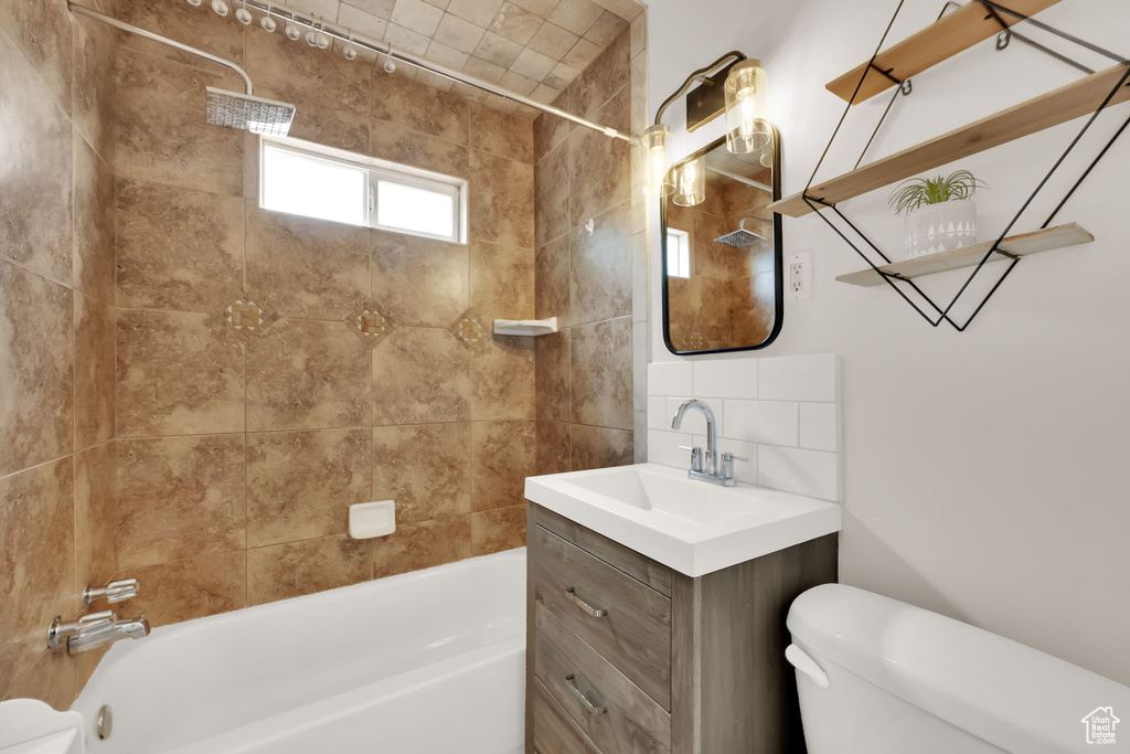 Full bathroom with shower / bath combination, vanity, and backsplash
