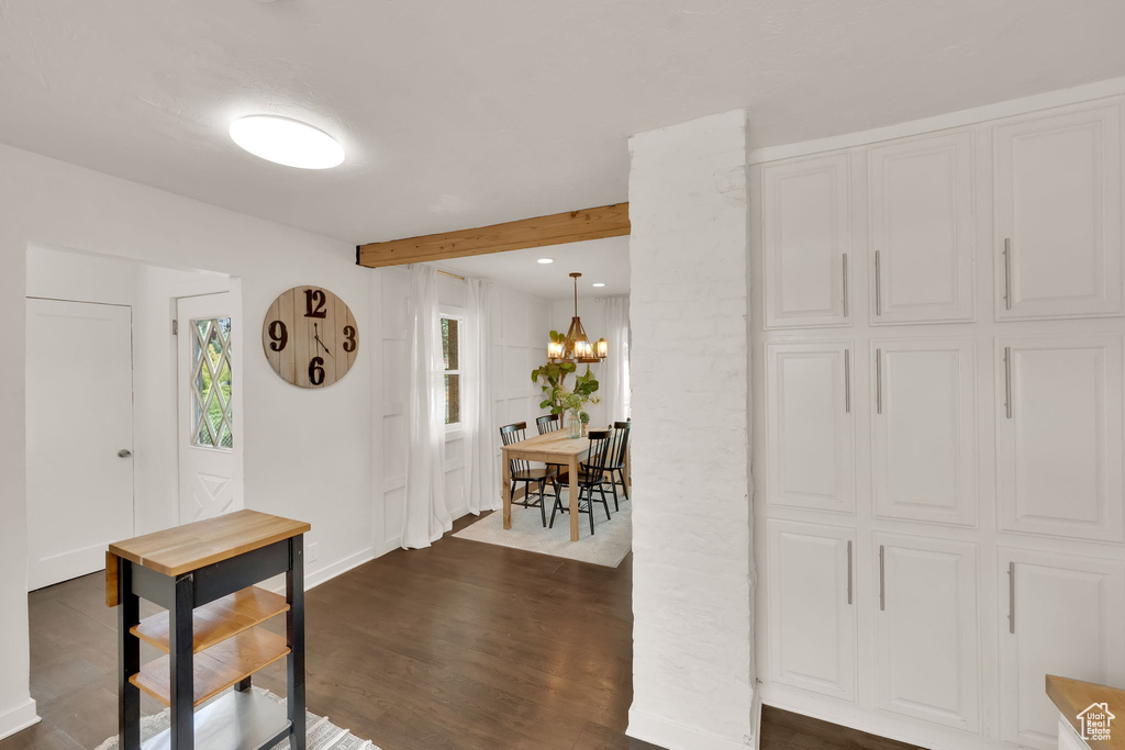 Foyer entrance featuring dark wood-type flooring, a chandelier, beam ceiling, and recessed lighting