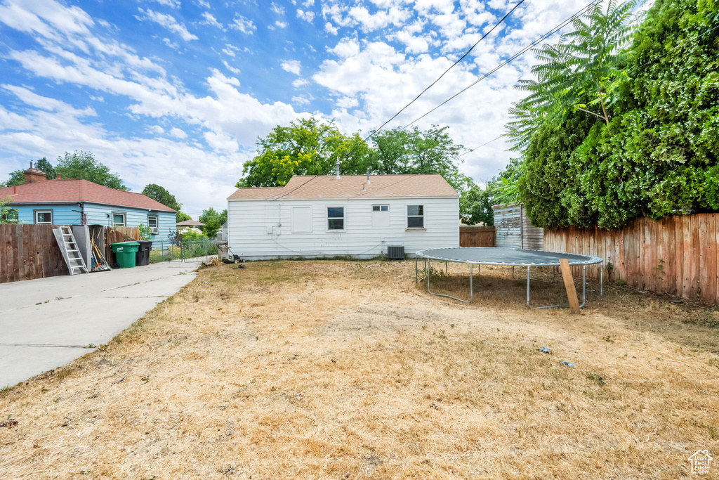 Rear view of property featuring a trampoline