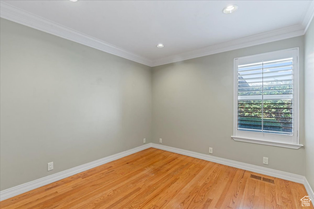 Spare room featuring light wood finished floors, ornamental molding, and recessed lighting