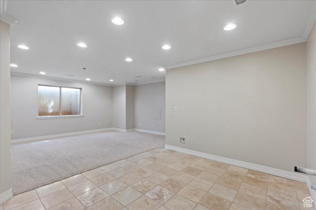 Spare room featuring light carpet, ornamental molding, and recessed lighting