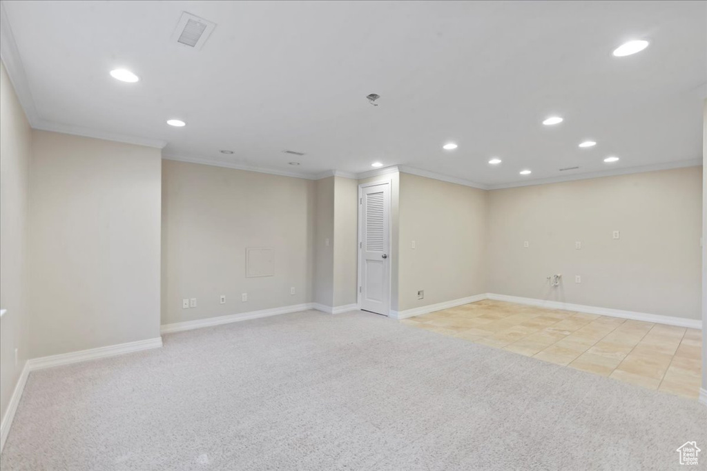 Unfurnished room with crown molding, recessed lighting, light carpet, and light tile patterned flooring
