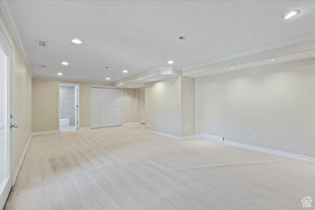 Below grade area featuring ornamental molding, recessed lighting, and light colored carpet