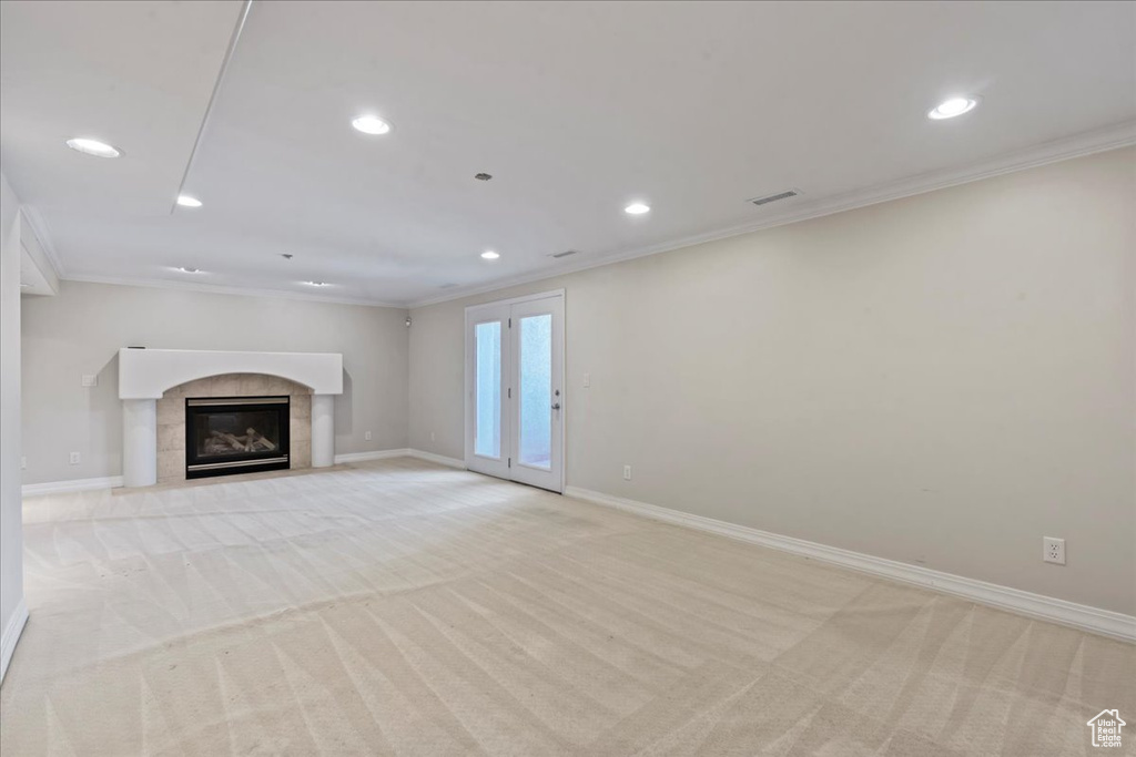 Unfurnished living room with light colored carpet, ornamental molding, recessed lighting, and a fireplace