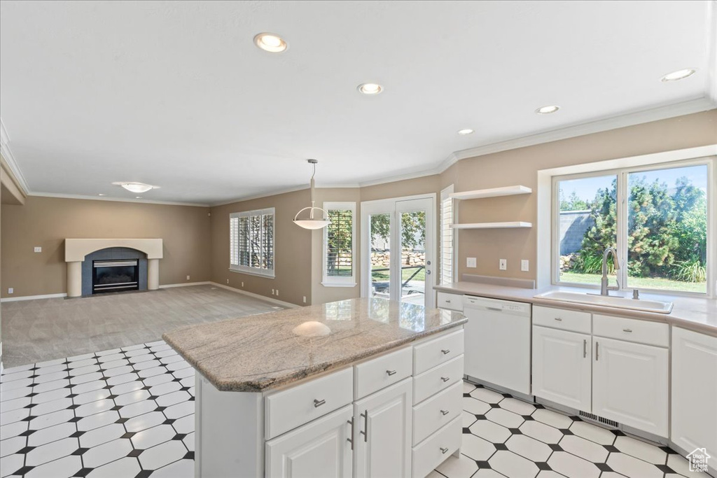 Kitchen featuring white dishwasher, light flooring, a glass covered fireplace, a center island, and open shelves