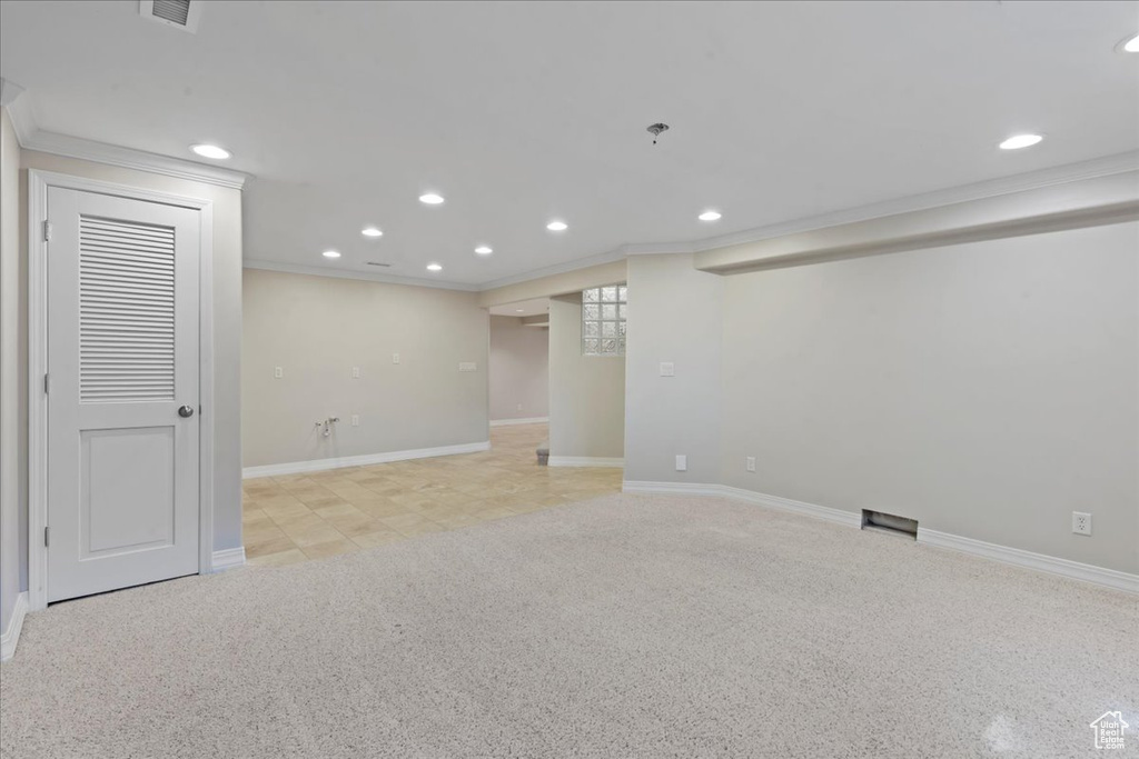 Finished basement featuring ornamental molding and recessed lighting
