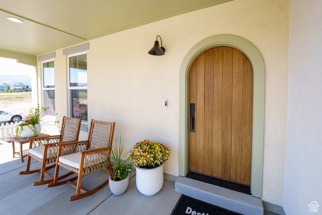 Doorway to property featuring a porch and stucco siding