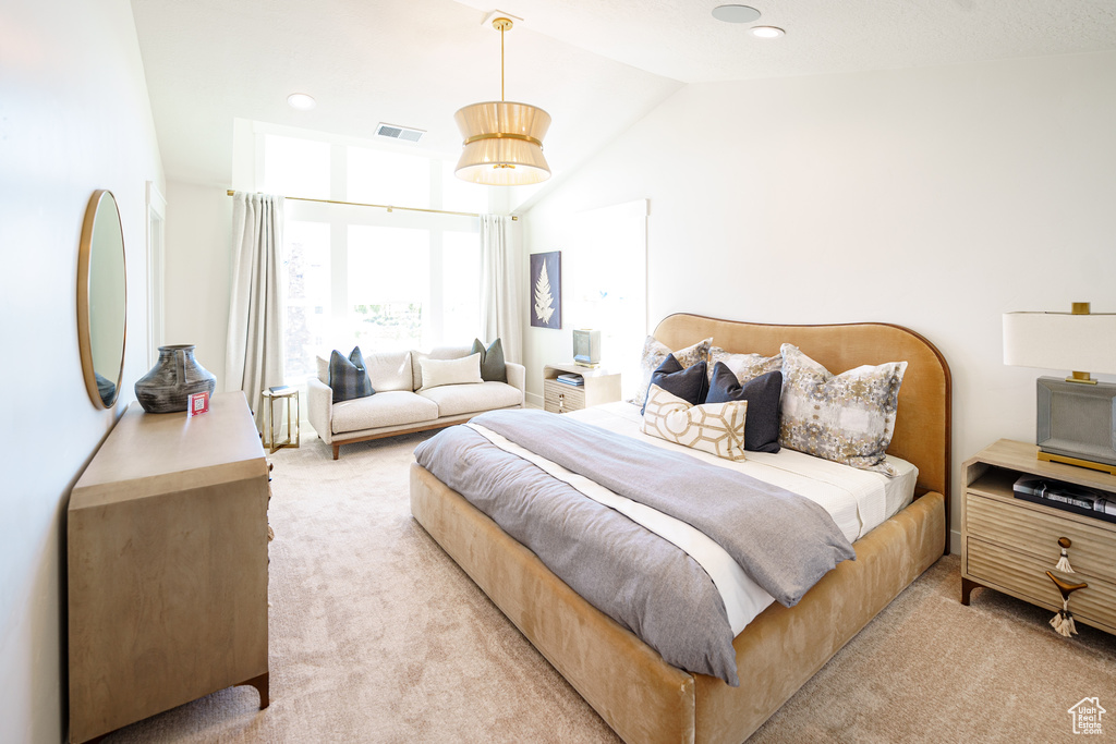 Bedroom with light colored carpet, lofted ceiling, and recessed lighting