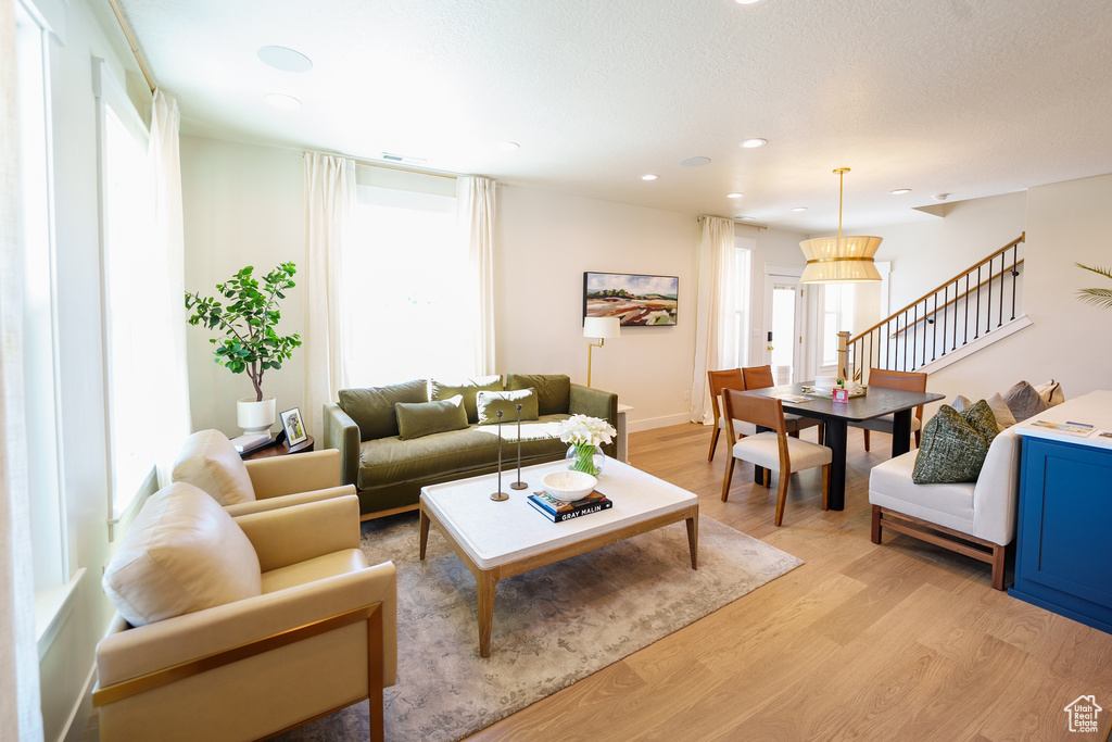 Living area with light wood-style flooring and recessed lighting