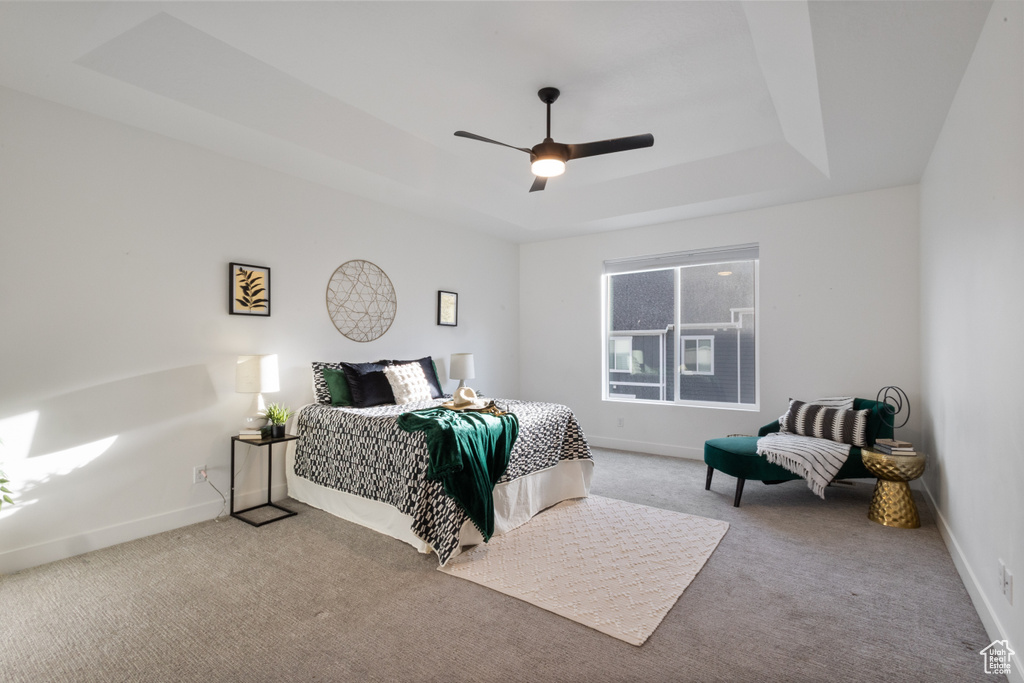 Bedroom featuring carpet flooring, ceiling fan, and a tray ceiling