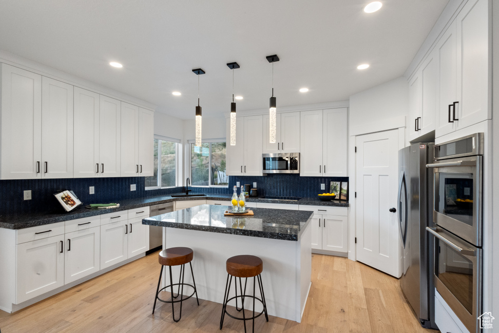 Kitchen with stainless steel appliances, white cabinetry, and recessed lighting