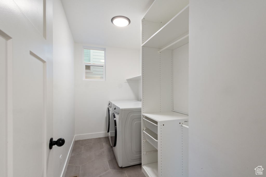 Washroom with independent washer and dryer and light tile patterned floors