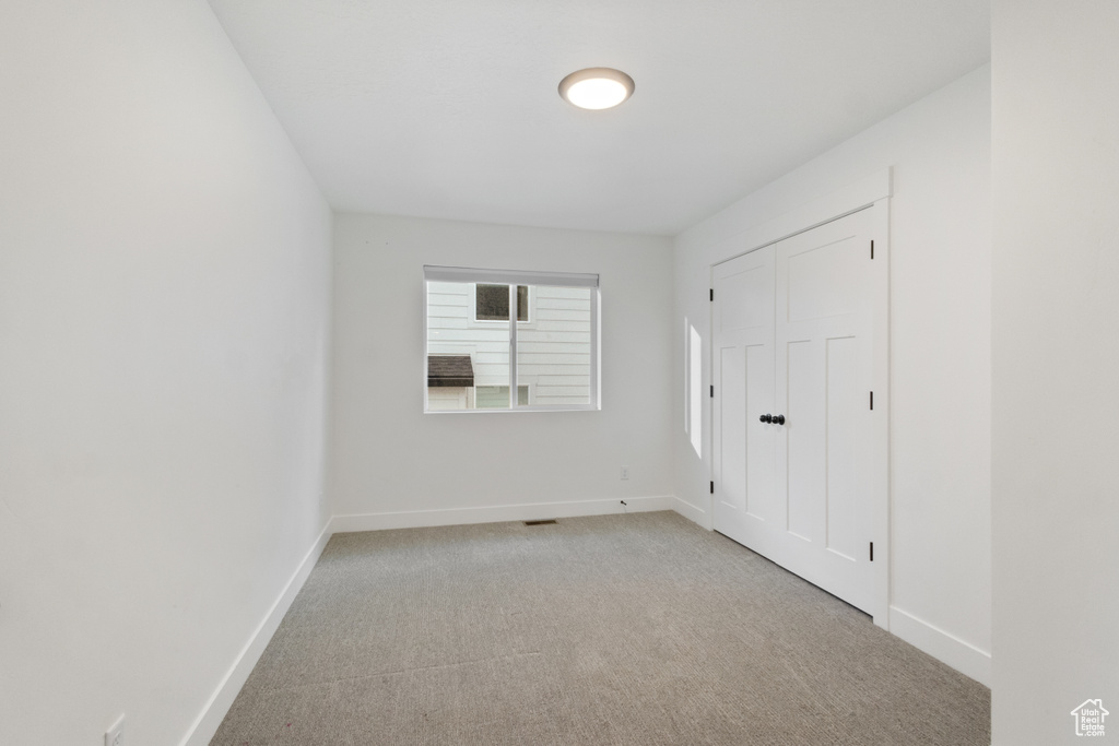 Unfurnished bedroom featuring carpet flooring and a closet