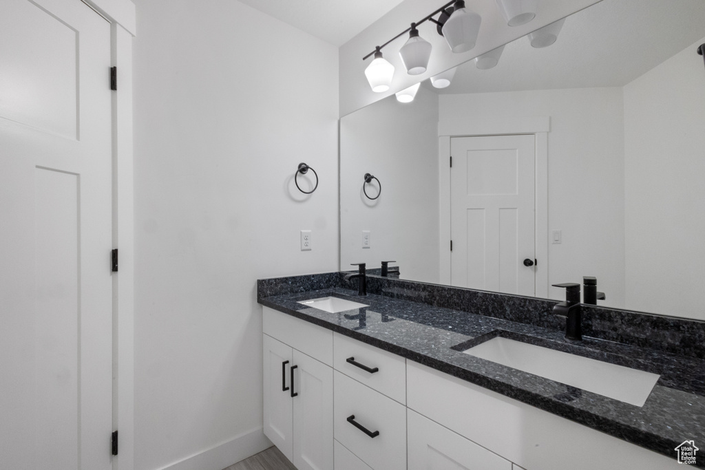 Full bath with double vanity and baseboards