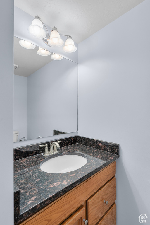 Half bathroom with vanity and toilet