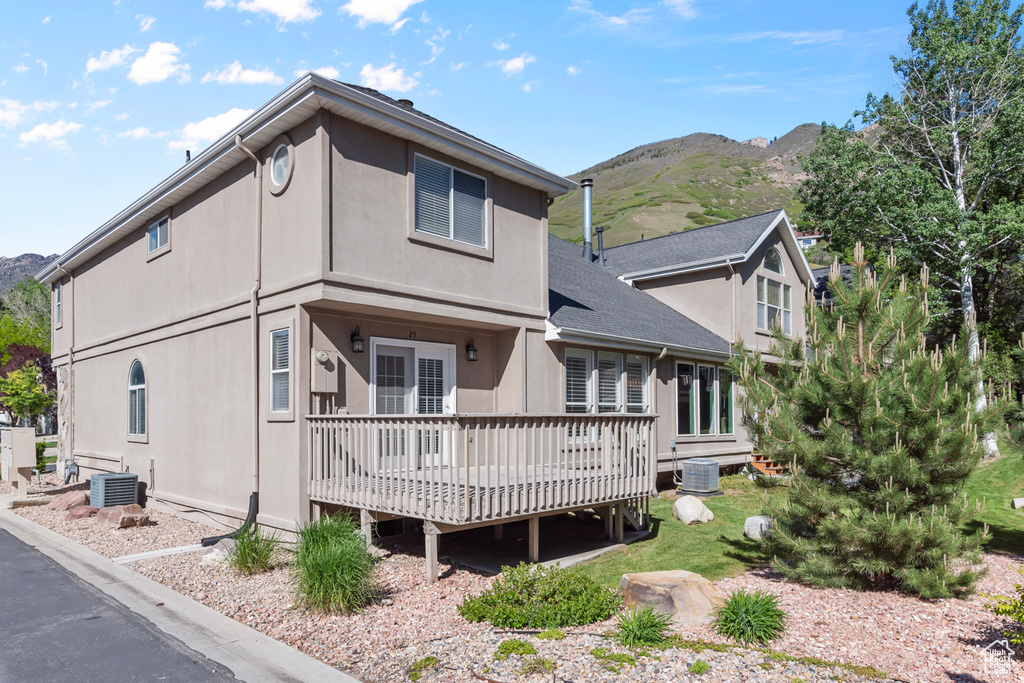 Back of property featuring a deck with mountain view and stucco siding