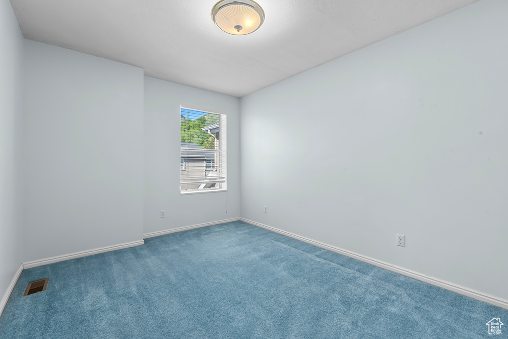 Carpeted spare room with baseboards