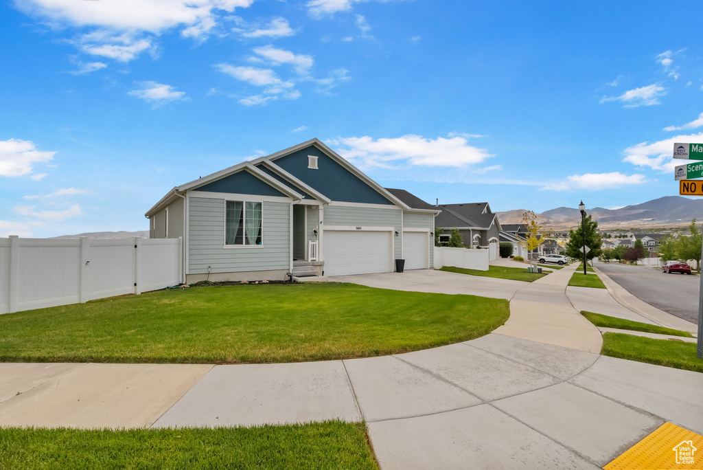 Ranch-style house featuring concrete driveway, a mountain view, and a garage