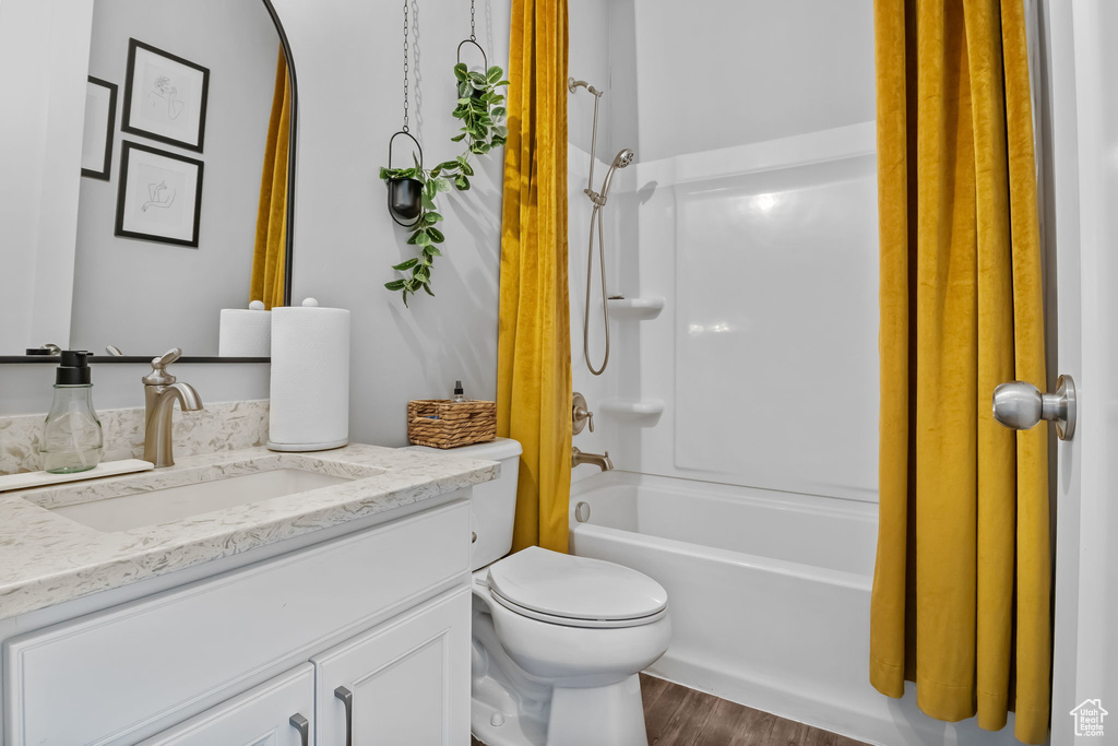 Bathroom featuring vanity, wood finished floors, and bathing tub / shower combination