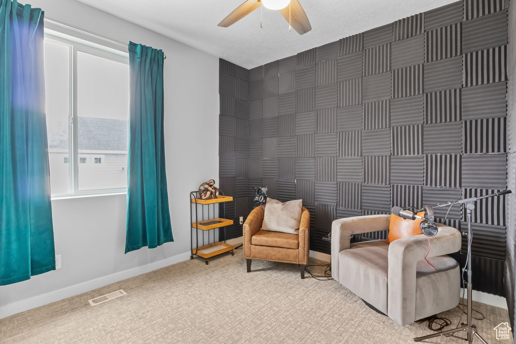Living area featuring a ceiling fan and carpet flooring