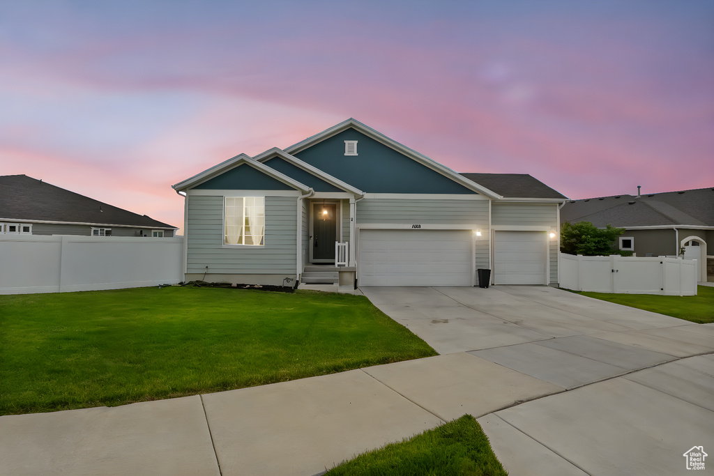 Single story home with an attached garage, driveway, and a gate