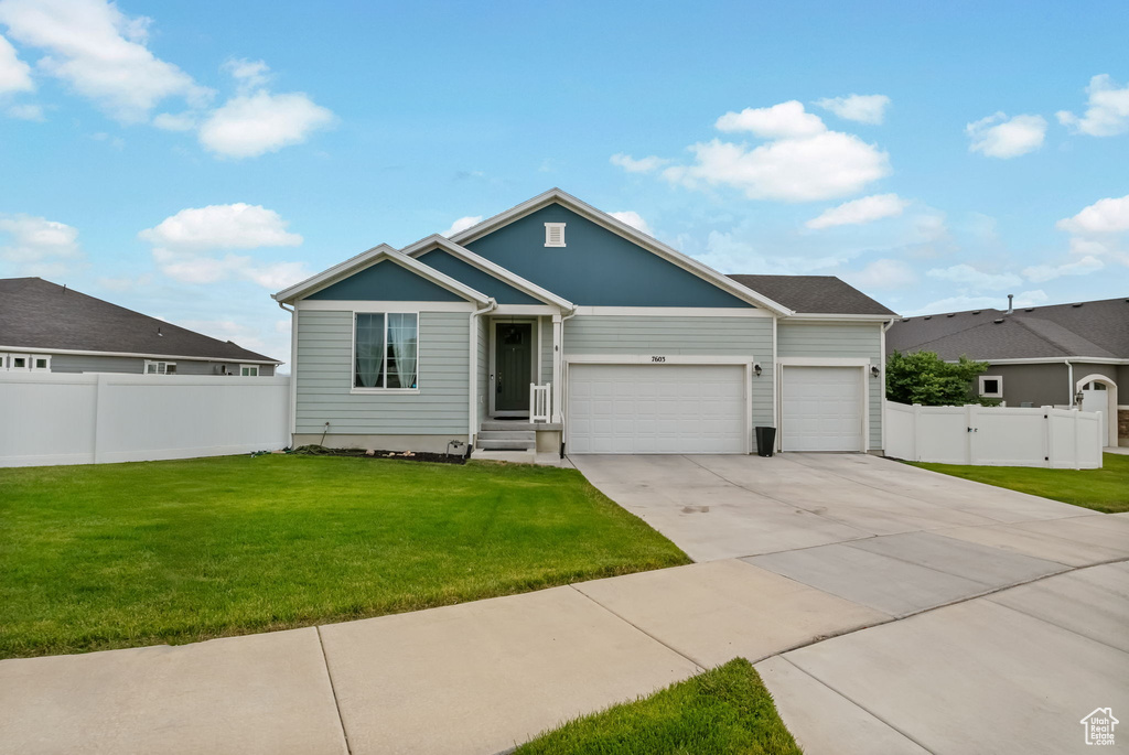 Single story home featuring an attached garage, driveway, and a gate