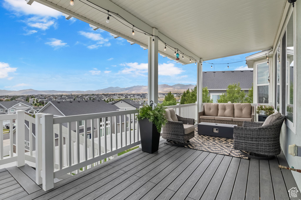 Deck featuring an outdoor living space, a mountain view, and a residential view