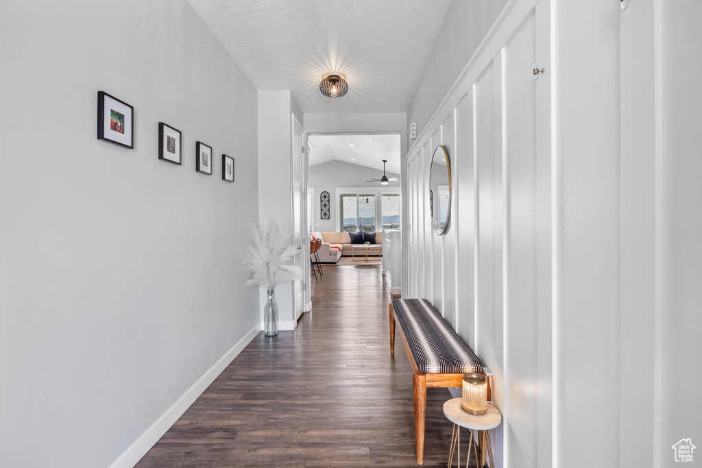 Corridor with vaulted ceiling and dark wood finished floors