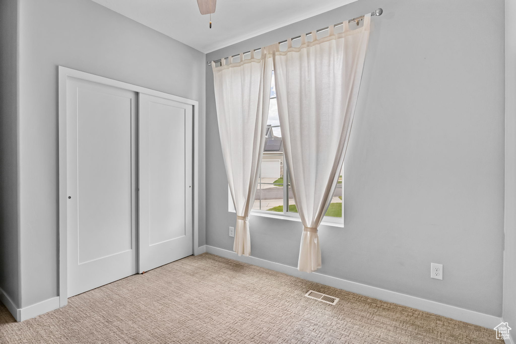 Unfurnished bedroom featuring carpet, a closet, and ceiling fan