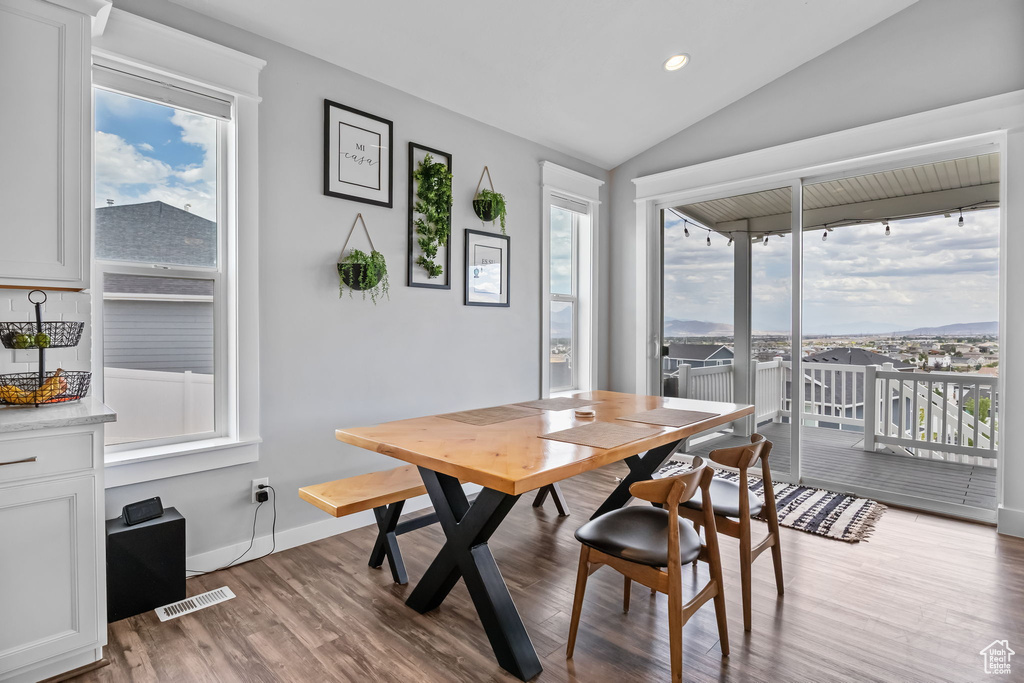 Dining area featuring wood finished floors, lofted ceiling, and recessed lighting