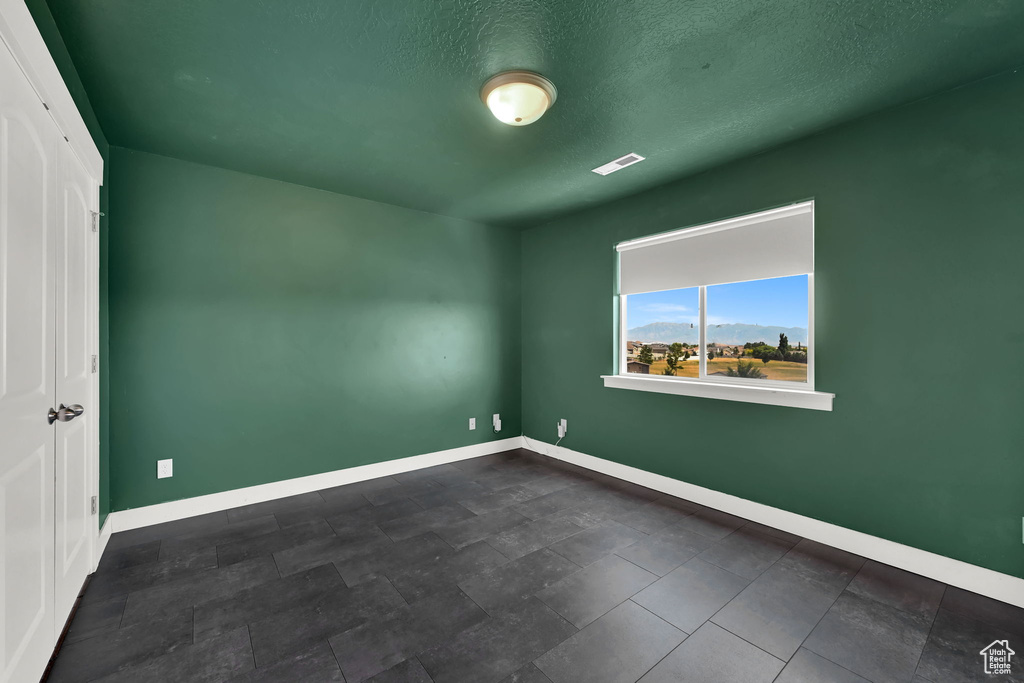 Empty room with baseboards and a textured ceiling