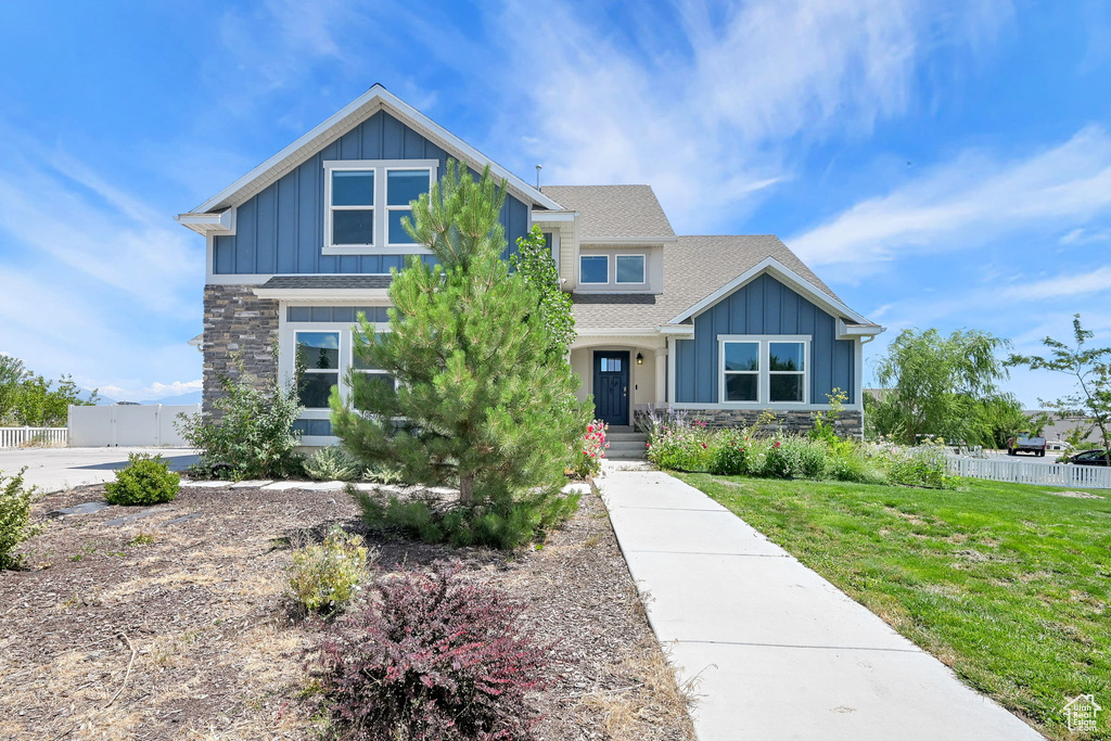 Craftsman inspired home featuring board and batten siding, stone siding, and roof with shingles