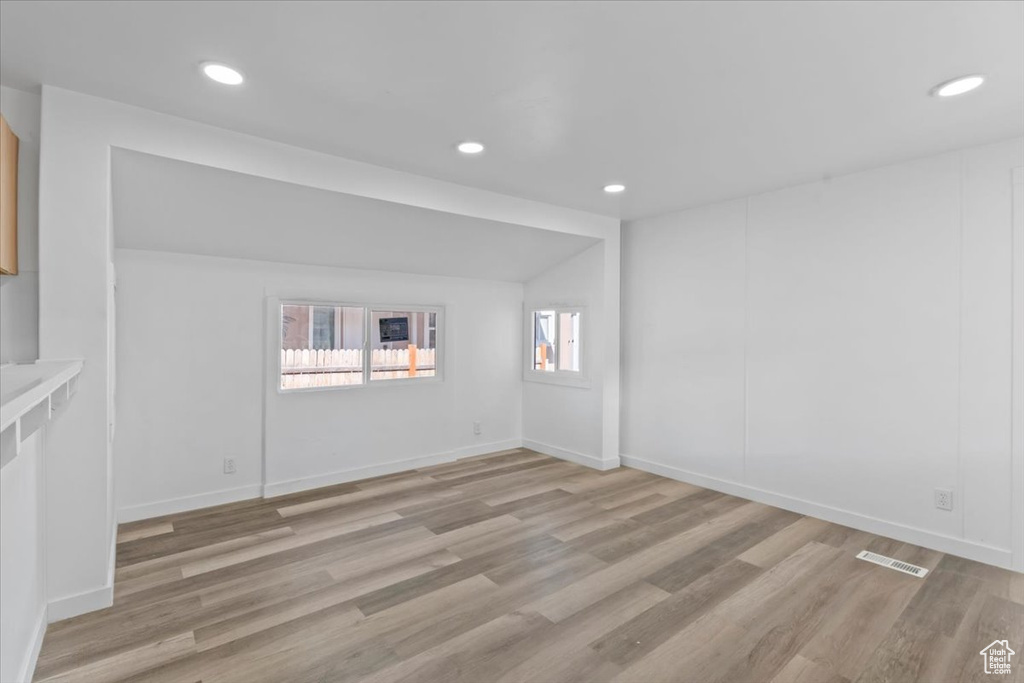 Empty room with light wood finished floors and recessed lighting