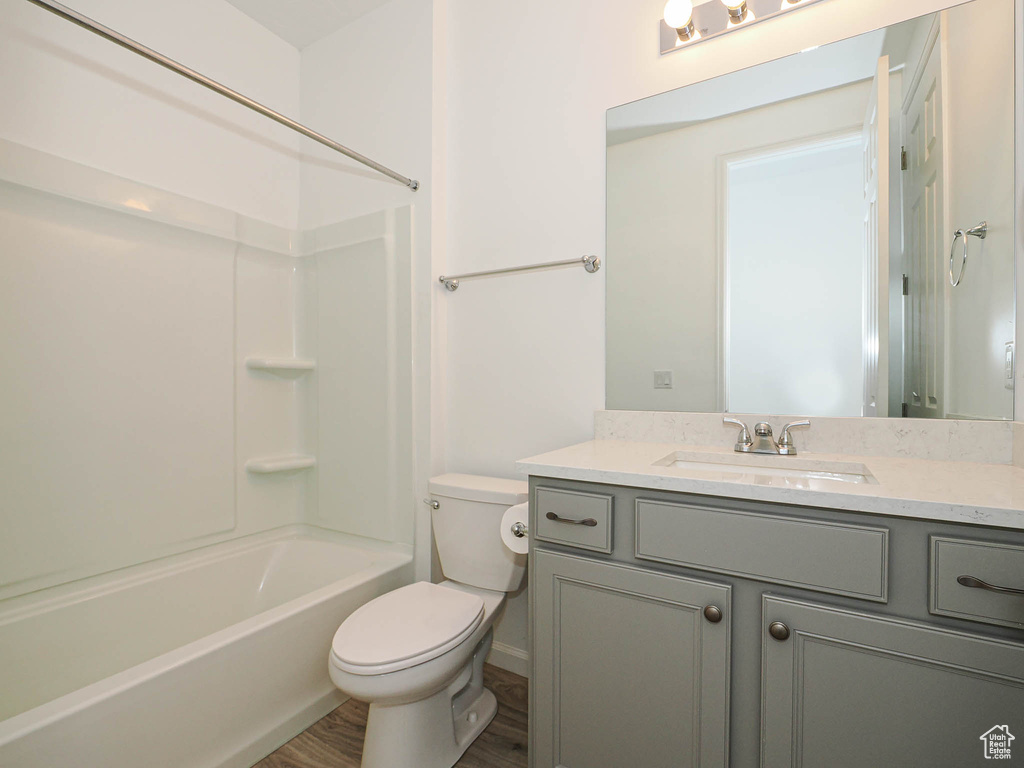 Bathroom featuring vanity, washtub / shower combination, and wood finished floors