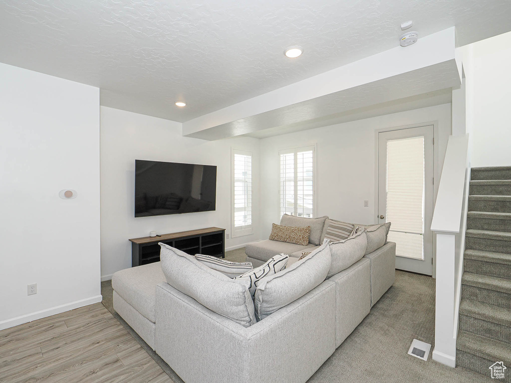 Living area with stairs, light wood-type flooring, and recessed lighting
